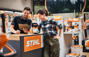 Un chico reparando la maquinaria de jardineria de la clienta